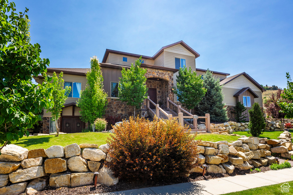 View of front of home featuring stone siding and a front lawn