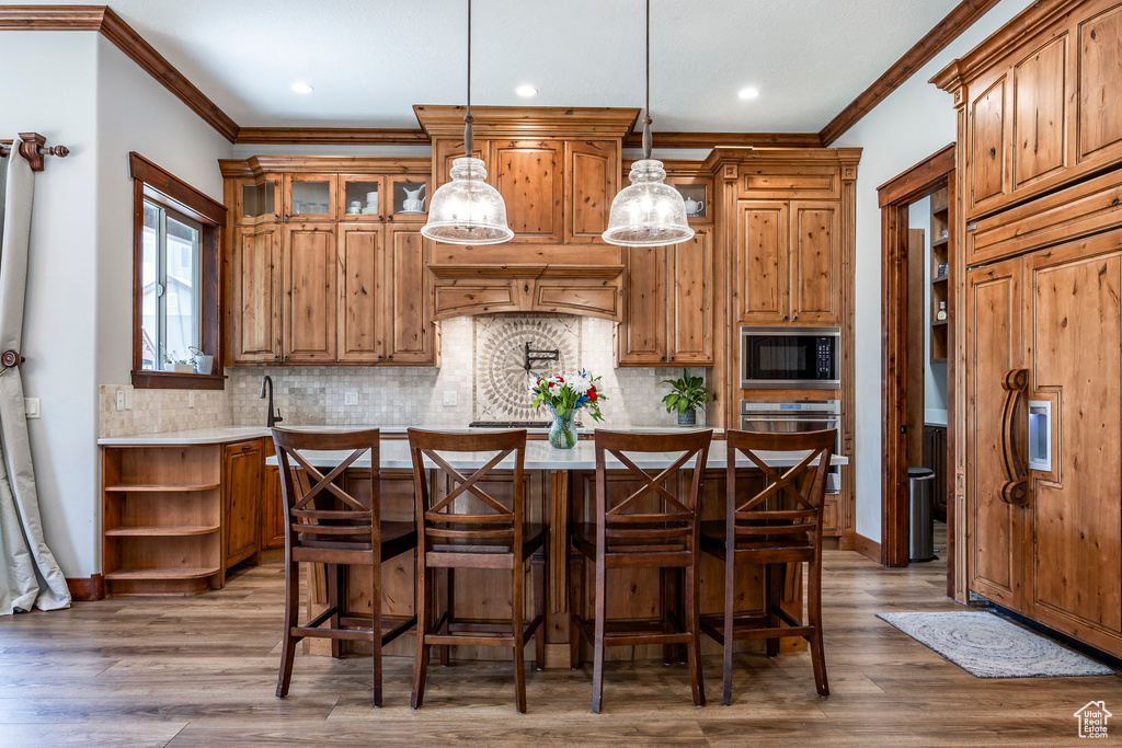 Kitchen with stainless steel oven, black microwave, open shelves, light countertops, and decorative backsplash