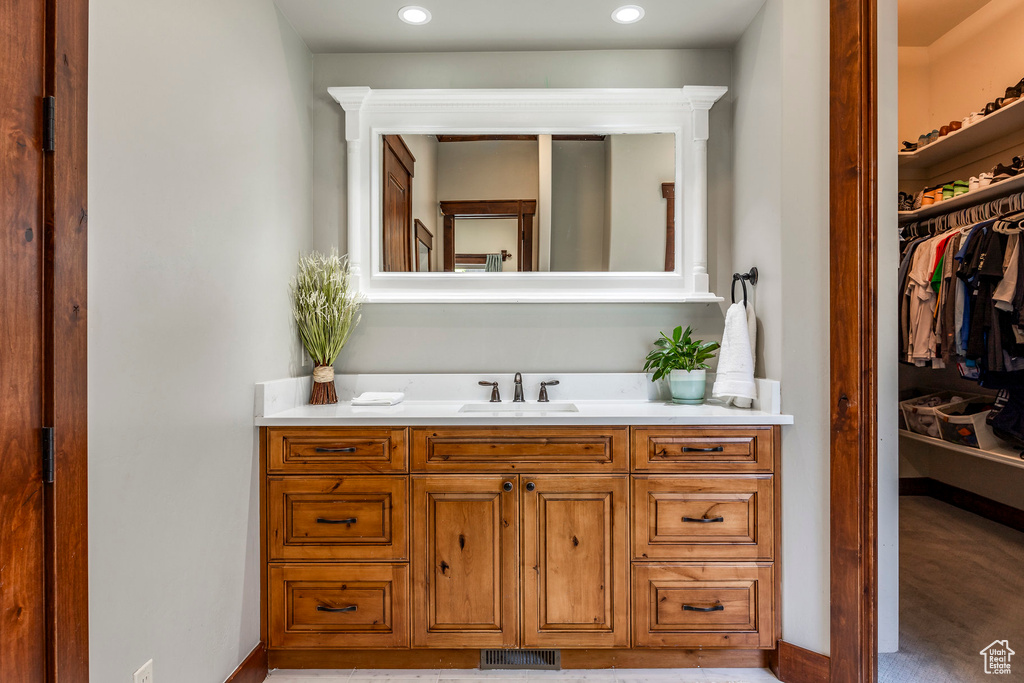 Bathroom with vanity, baseboards, visible vents, and recessed lighting