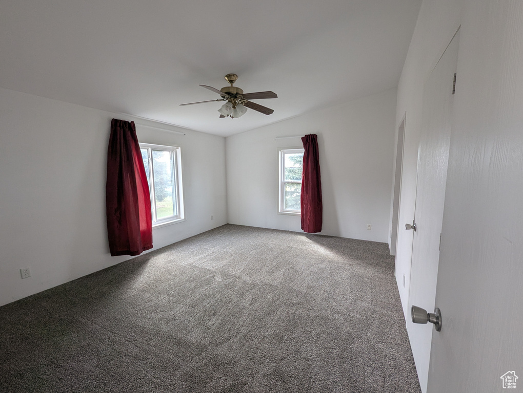 Carpeted empty room featuring a ceiling fan