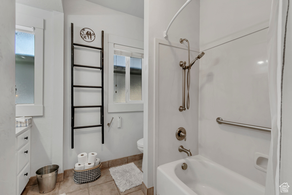 Bathroom featuring vanity, baseboards, tile patterned flooring, toilet, and shower / bathing tub combination