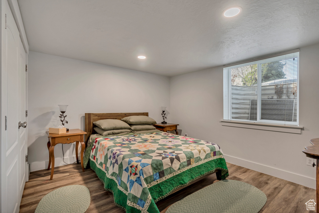 Bedroom featuring recessed lighting, baseboards, a textured ceiling, and wood finished floors