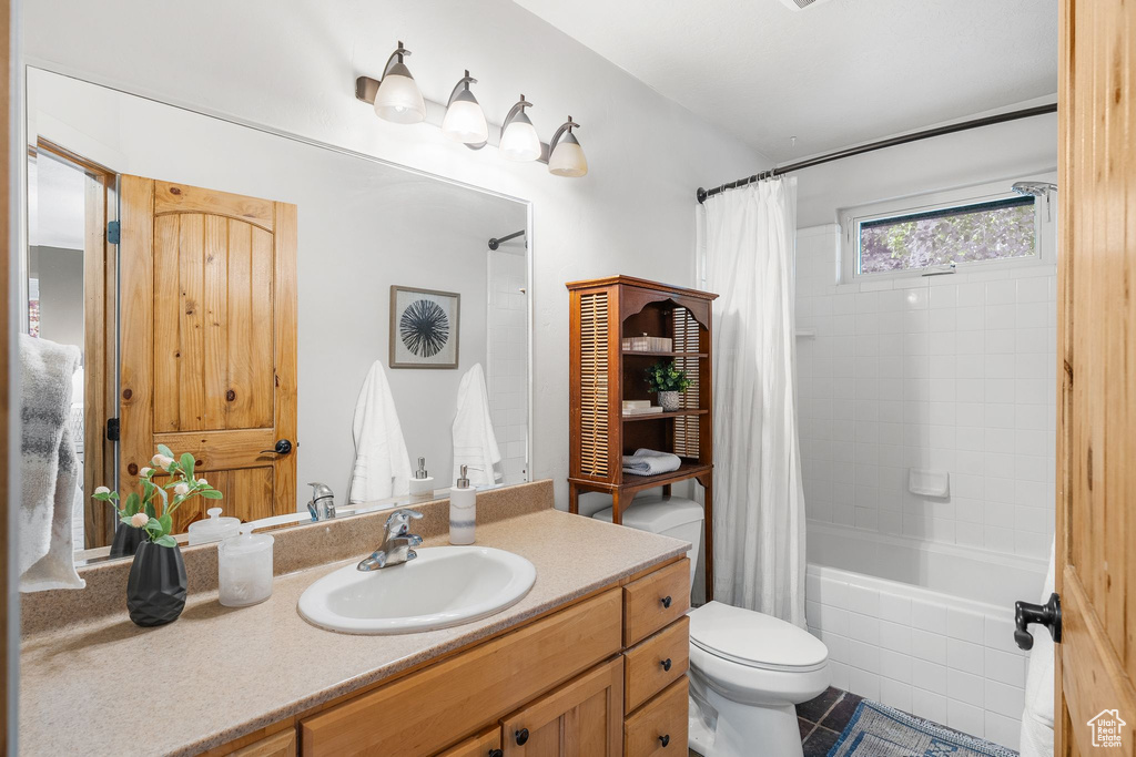 Bathroom featuring vanity, shower / tub combo, and tile patterned floors