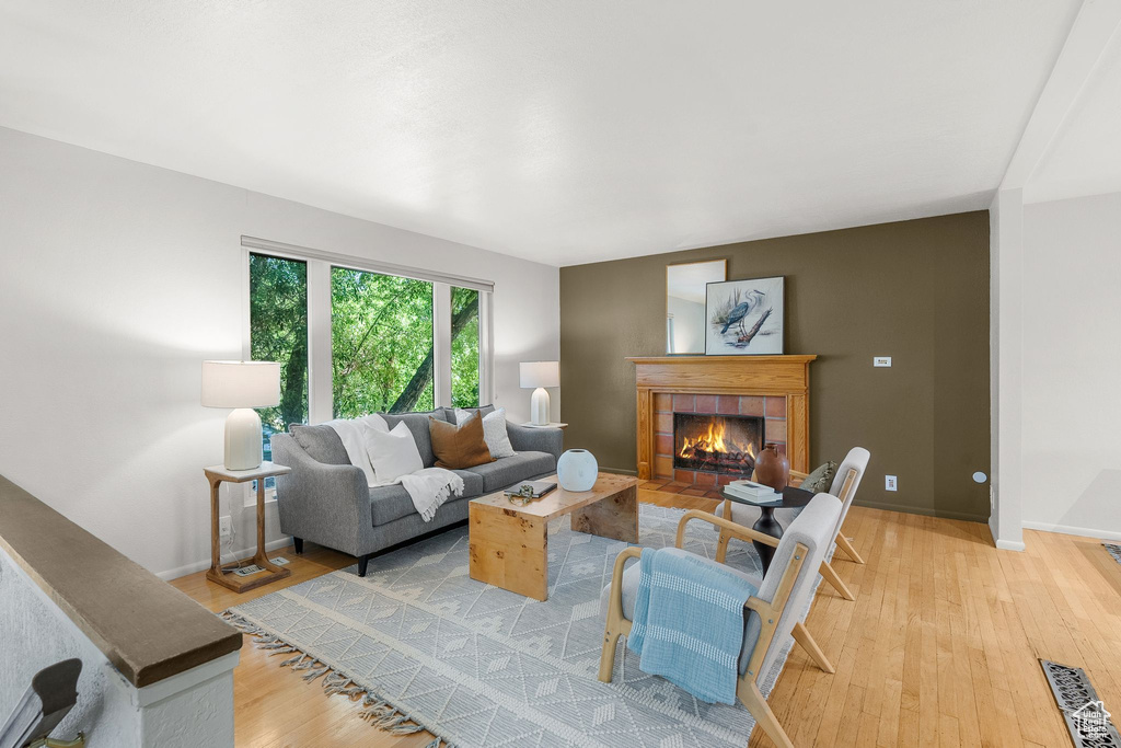 Living room with light wood-style floors and a tiled fireplace