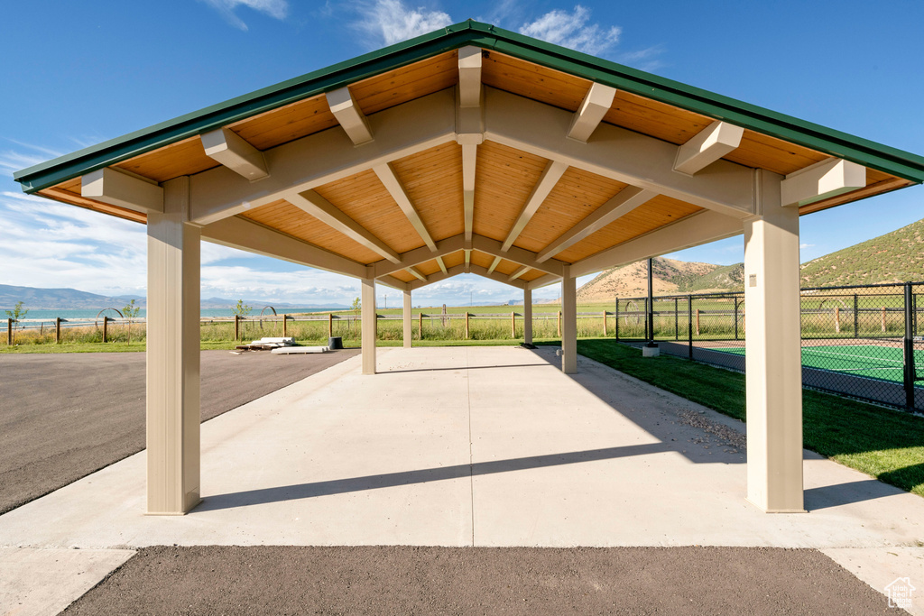 View of property\'s community featuring a mountain view, fence, and a patio