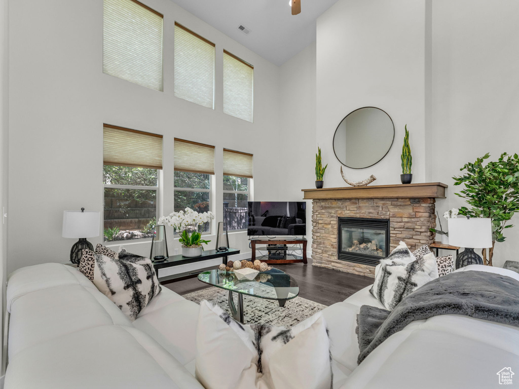 Living area featuring a high ceiling, wood finished floors, and a fireplace