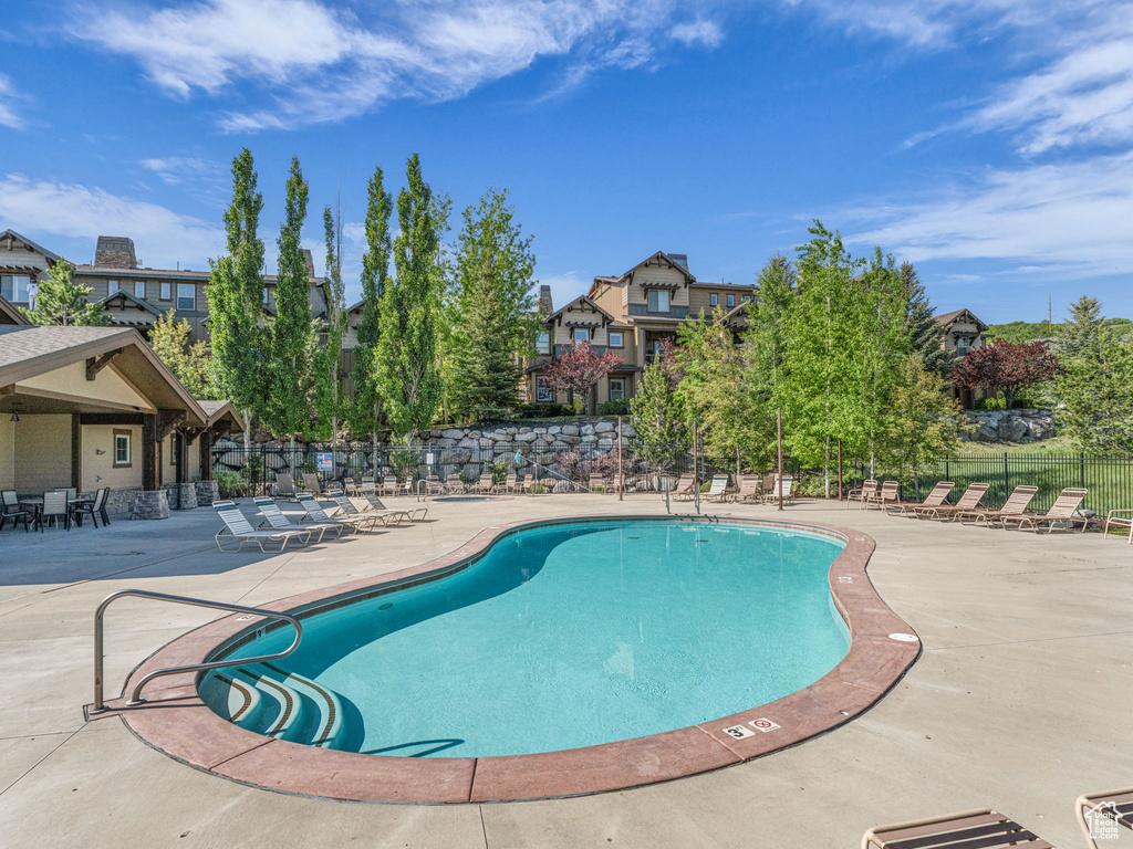 Community pool featuring a patio area and a residential view