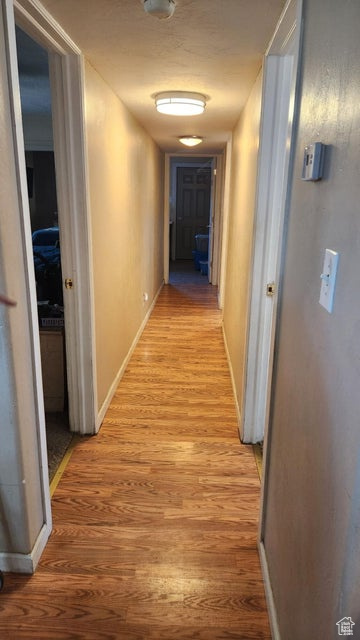 Hallway featuring light wood-style floors