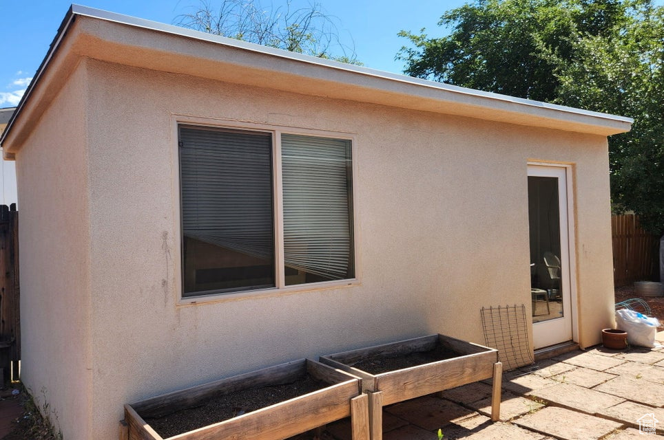 View of property exterior with stucco siding and a patio