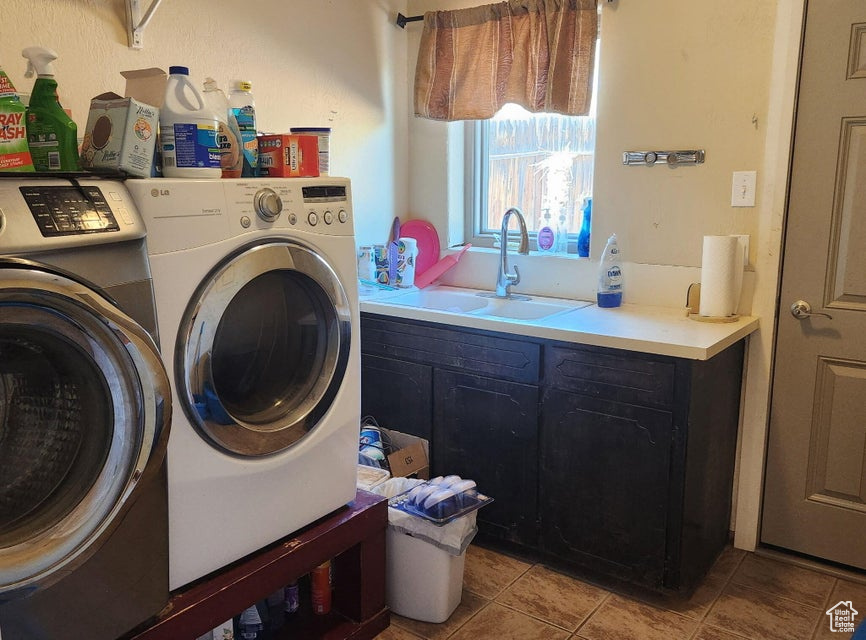 Laundry area with washing machine and clothes dryer and light tile patterned flooring