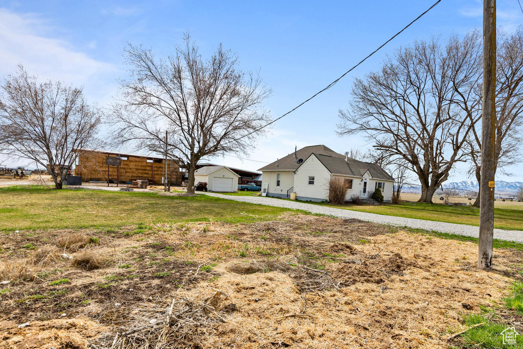 View of yard with driveway, a garage, and an outdoor structure