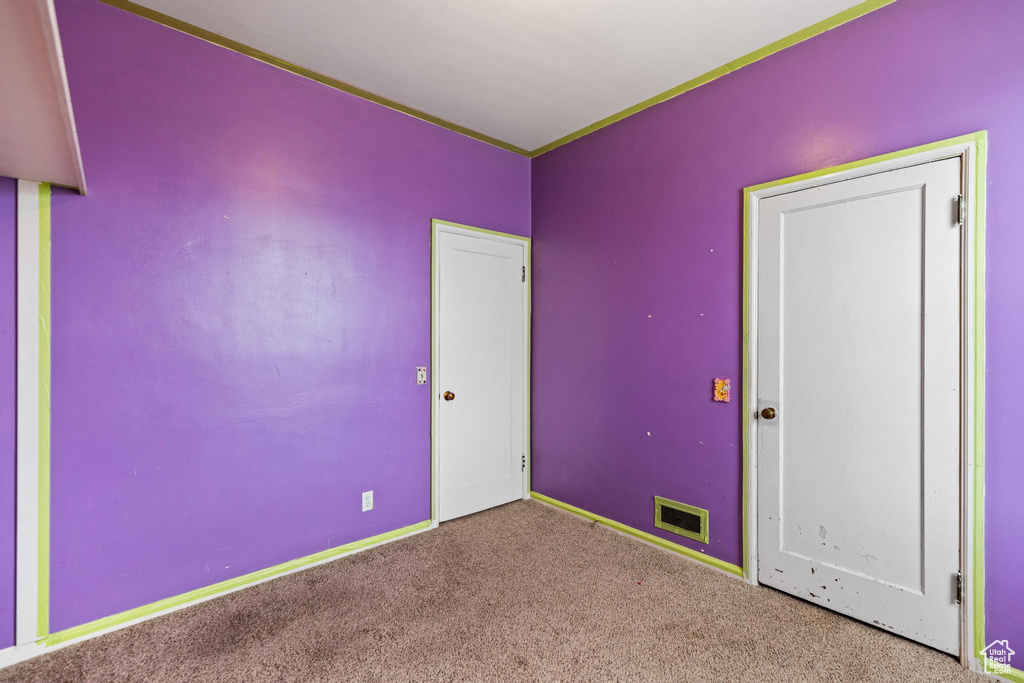 Unfurnished bedroom featuring baseboards, carpet floors, and visible vents