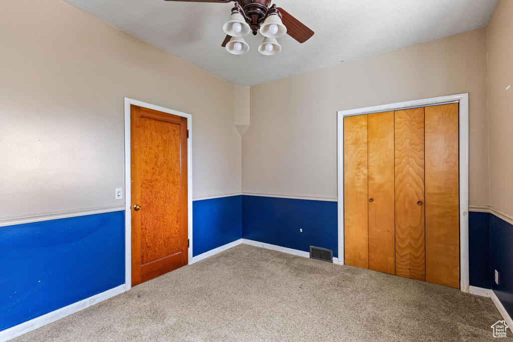 Unfurnished bedroom with baseboards, visible vents, ceiling fan, and carpet floors