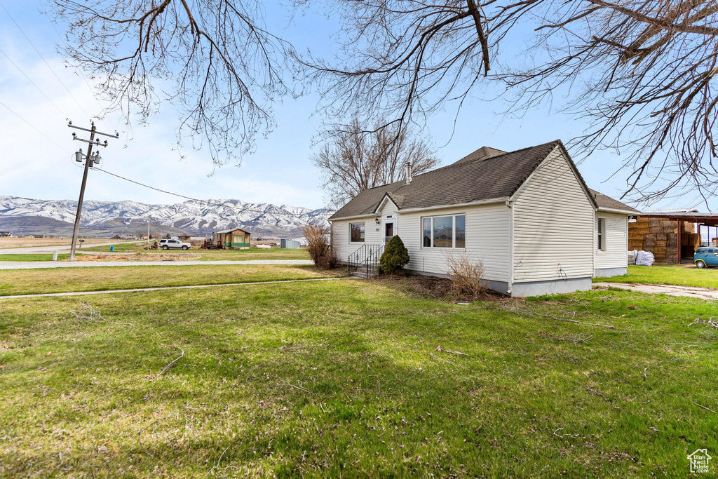 View of side of home with a lawn and a mountain view