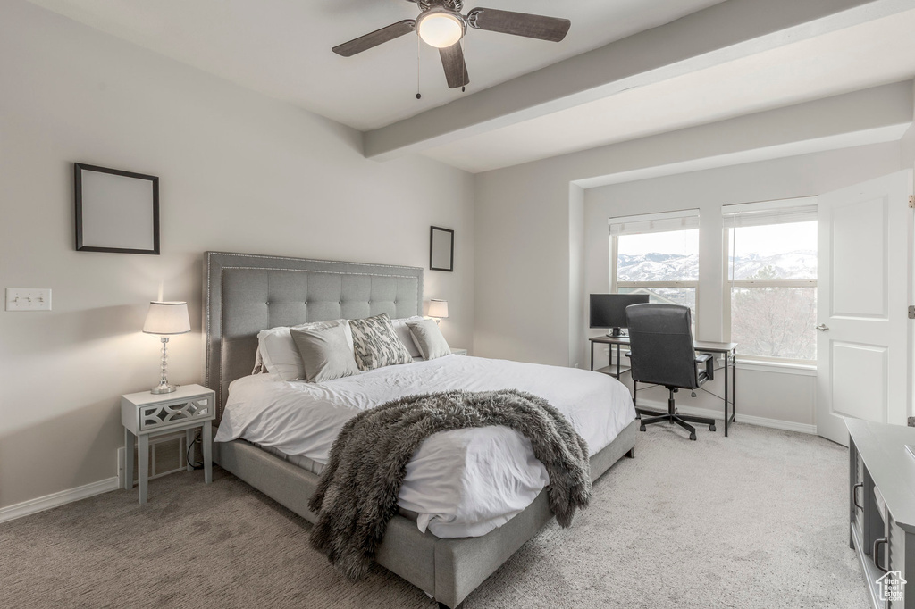Bedroom featuring light carpet, baseboards, beam ceiling, and a ceiling fan
