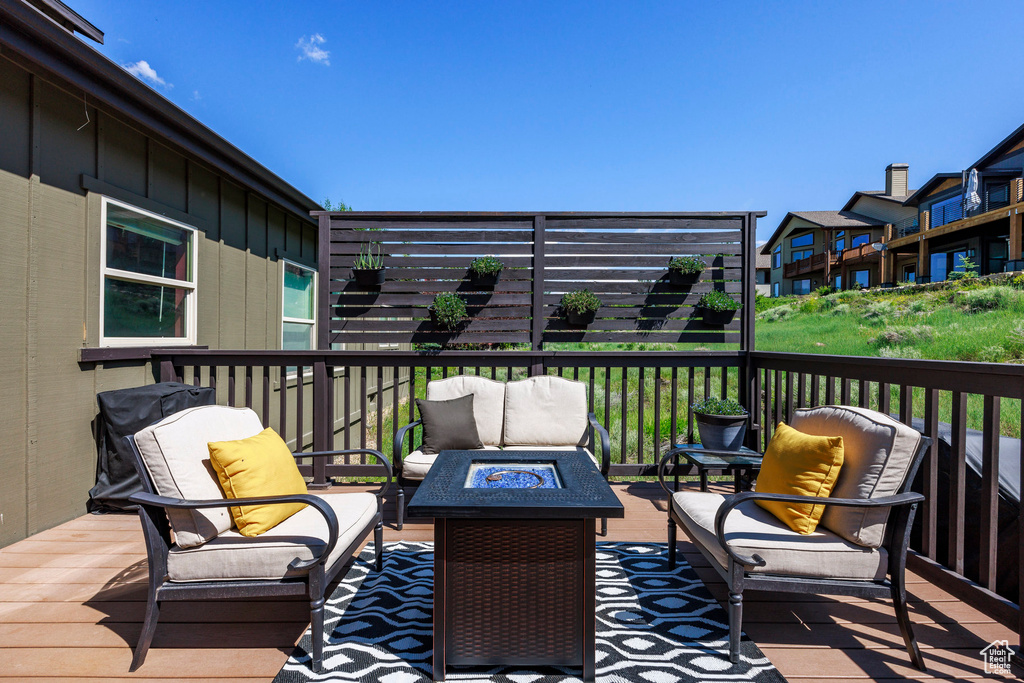 Wooden terrace featuring an outdoor living space with a fire pit