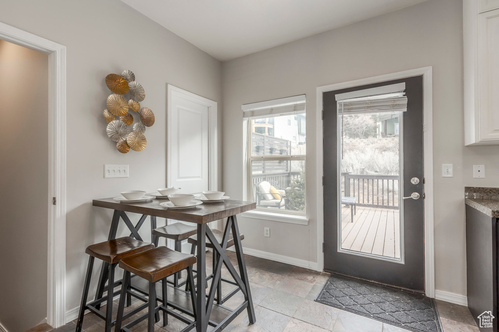 Dining space with baseboards and stone tile flooring