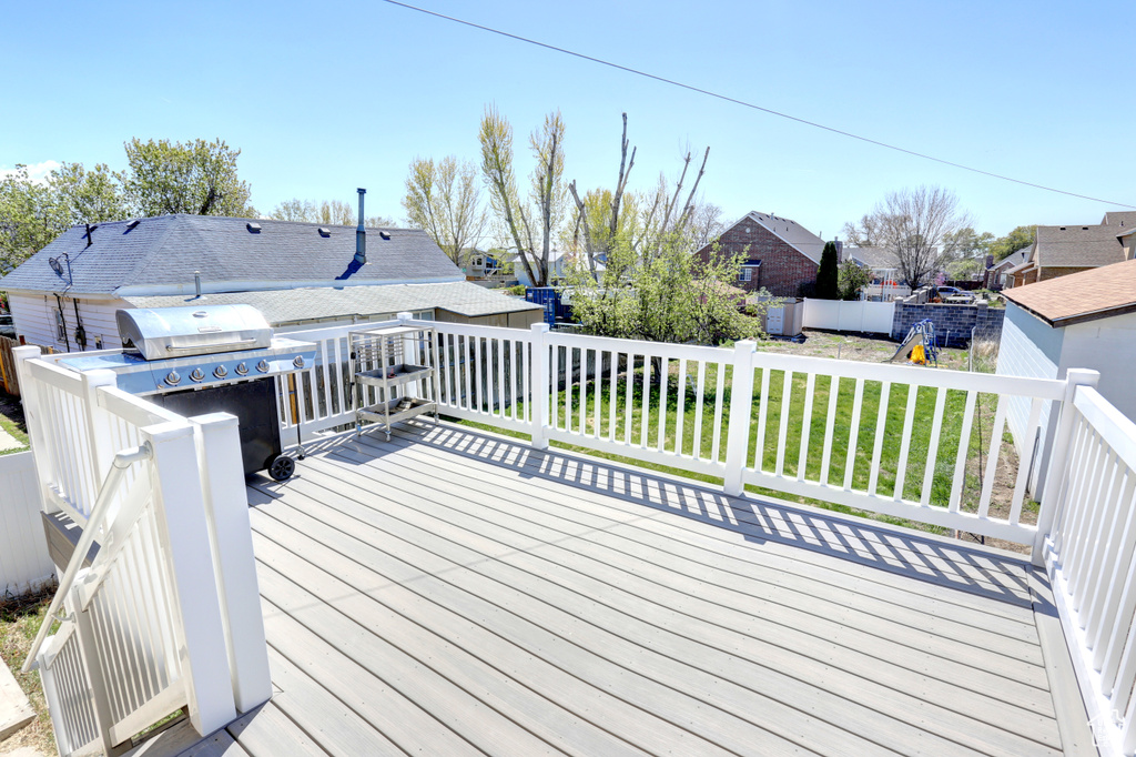 Wooden deck featuring a yard, a residential view, and fence