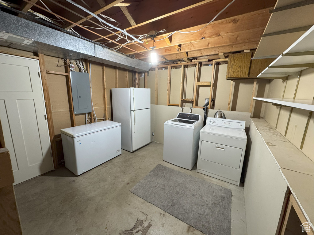 Laundry room featuring electric panel, washer and dryer, and laundry area