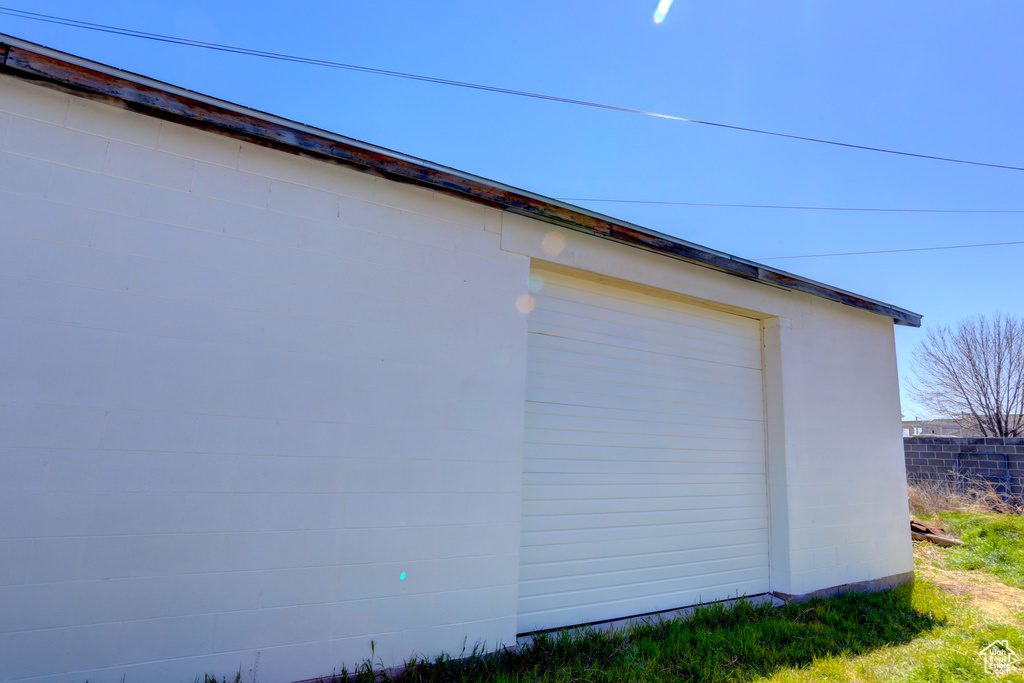 View of property exterior with an outbuilding and fence