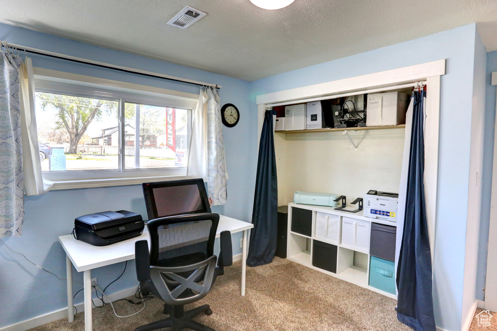 Office space with baseboards, visible vents, and carpet