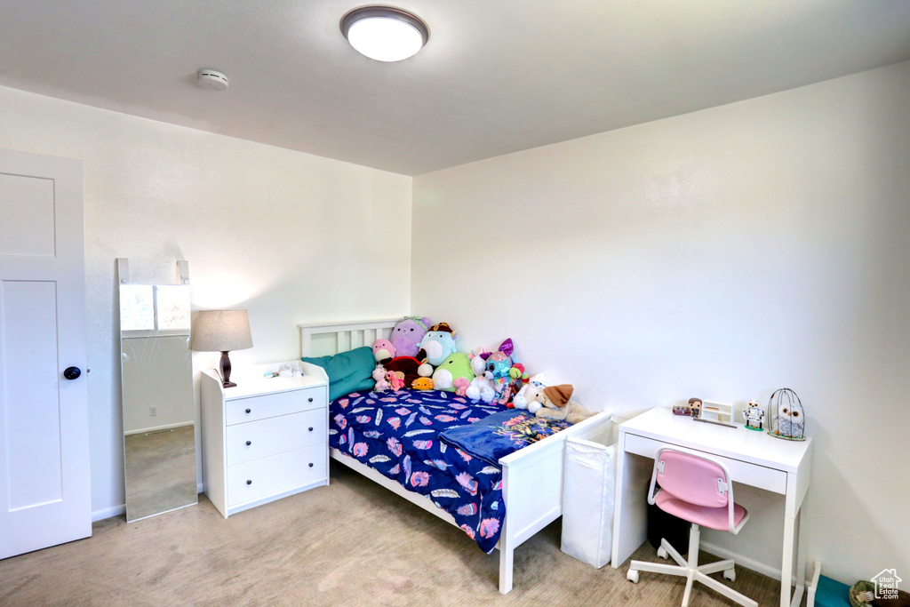 Bedroom featuring light carpet