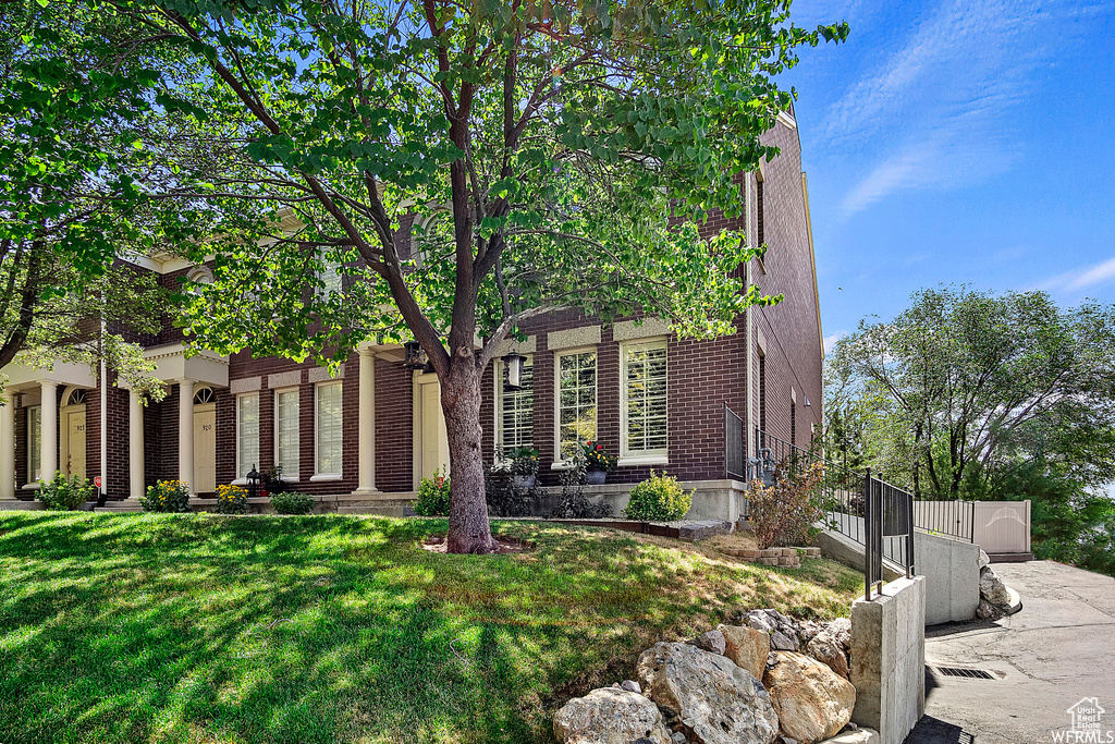 View of front of home with brick siding and a front yard