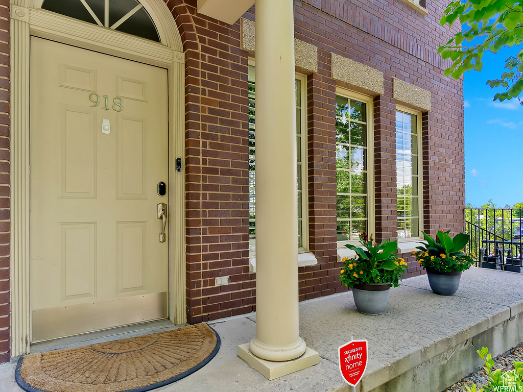 Property entrance featuring brick siding and covered porch