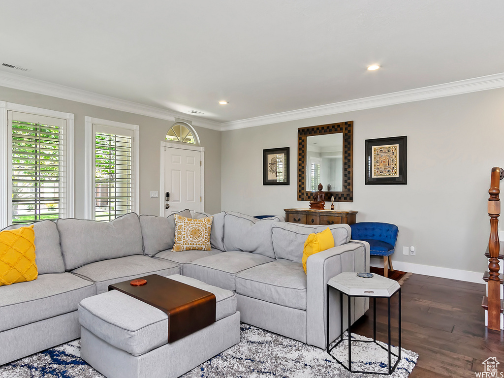 Living room with baseboards, recessed lighting, crown molding, visible vents, and wood finished floors