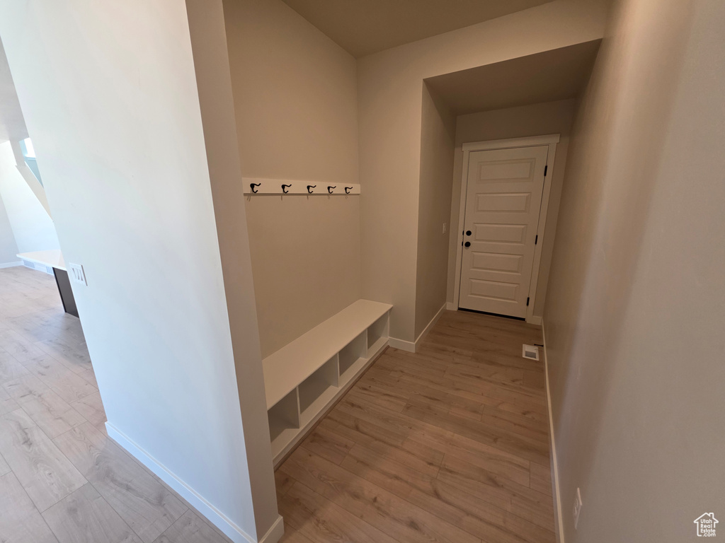 Mudroom featuring light wood finished floors and baseboards