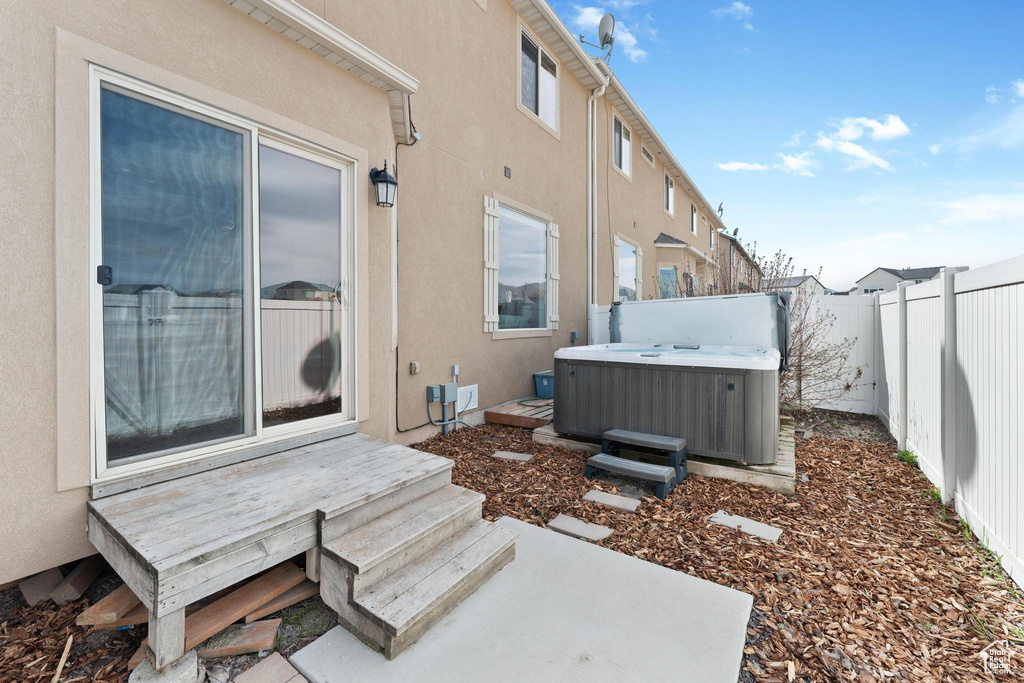 Exterior space featuring a fenced backyard, central AC unit, and a hot tub