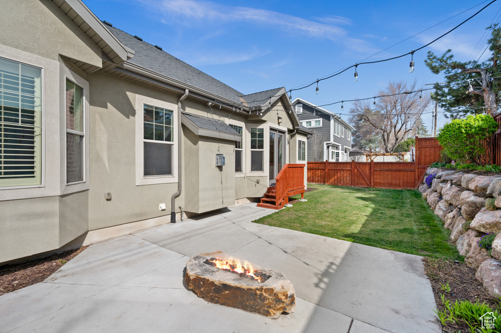 View of yard with an outdoor fire pit, a patio area, and fence