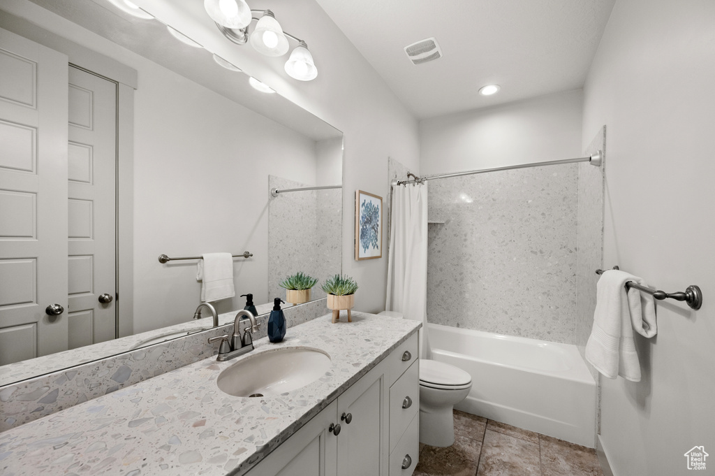 Bathroom with toilet, vanity, shower / bath combo with shower curtain, and visible vents