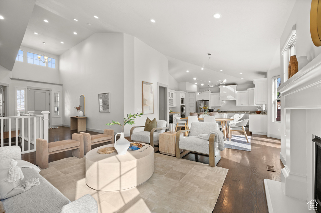 Living room featuring baseboards, recessed lighting, a chandelier, and wood finished floors