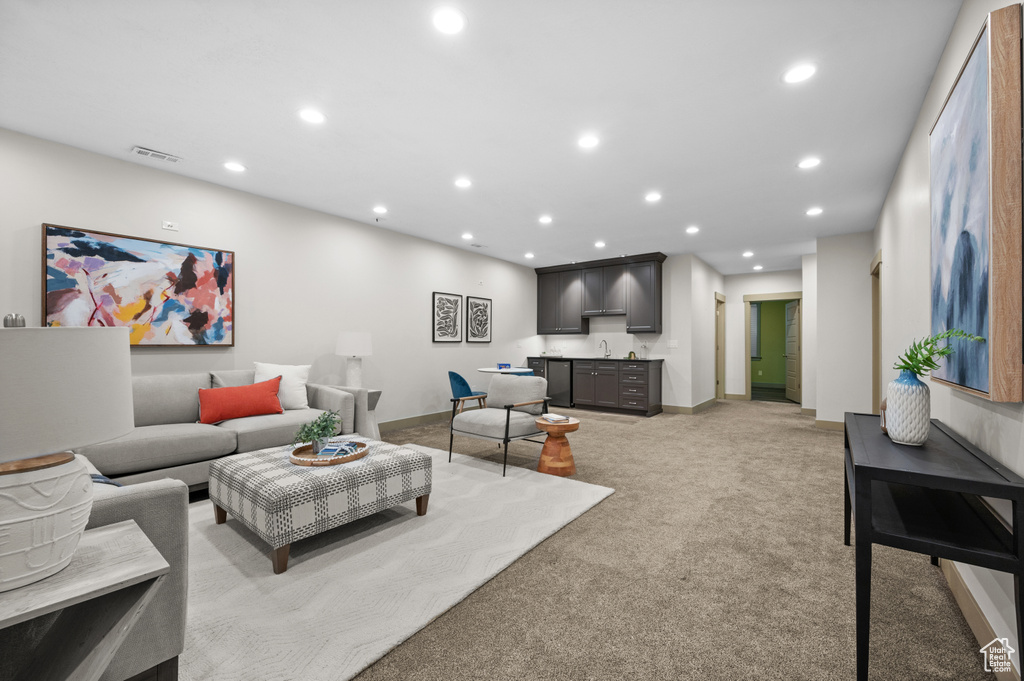 Living room with indoor wet bar, light colored carpet, visible vents, and recessed lighting