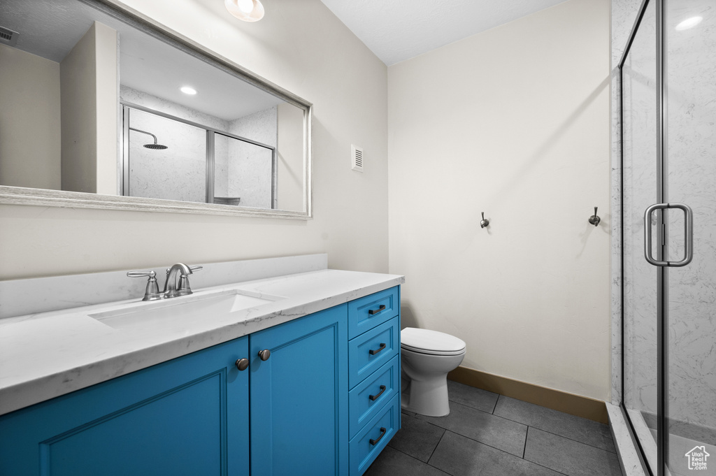 Bathroom featuring a shower stall, vanity, visible vents, toilet, and tile patterned floors