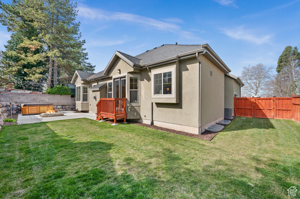Rear view of house with a patio, a fenced backyard, a gate, and a yard