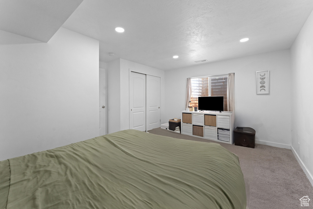 Carpeted bedroom with a closet, baseboards, and recessed lighting