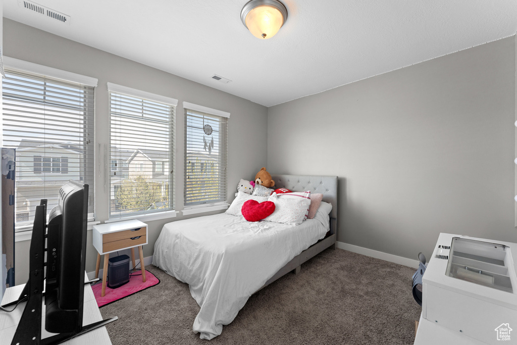 Bedroom with visible vents, baseboards, and carpet floors