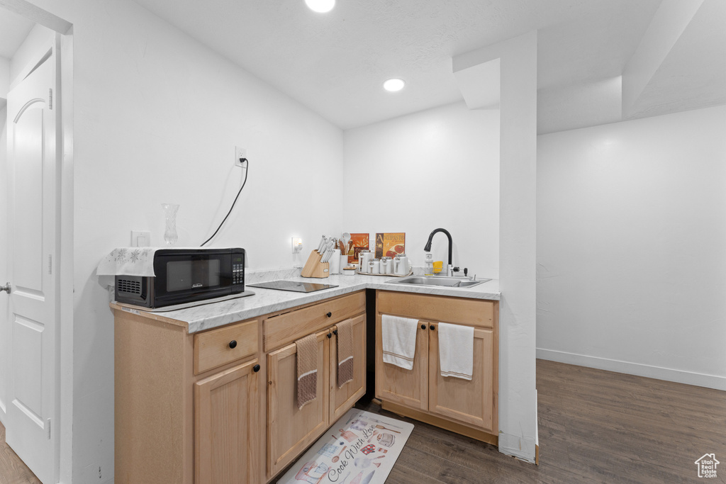 Kitchen featuring black appliances, recessed lighting, dark wood-style flooring, light countertops, and a sink