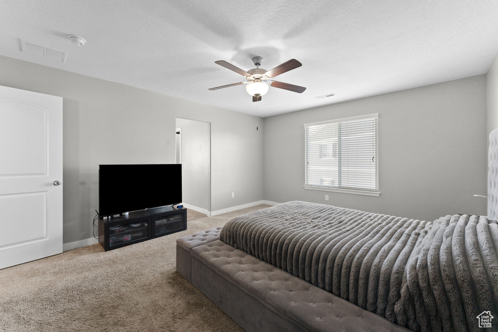 Bedroom featuring carpet floors, baseboards, visible vents, and a textured ceiling
