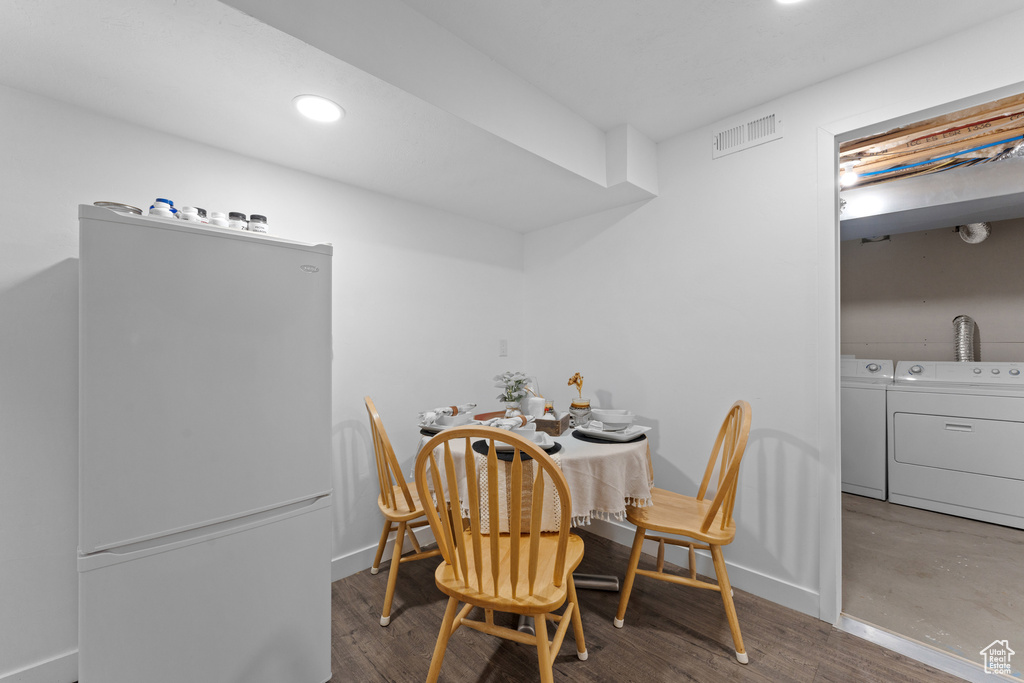 Dining room with separate washer and dryer, wood finished floors, baseboards, and visible vents