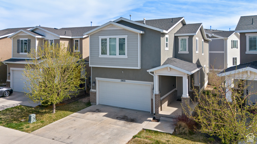 View of front facade with a residential view, a garage, stucco siding, and driveway