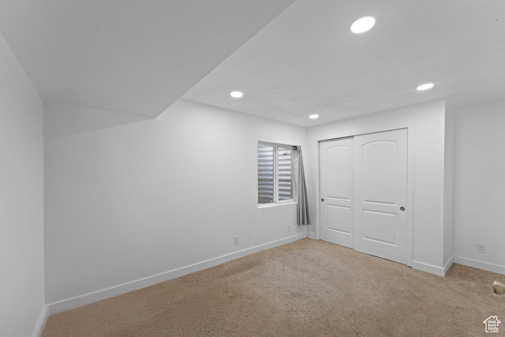 Below grade area with light colored carpet, baseboards, and recessed lighting
