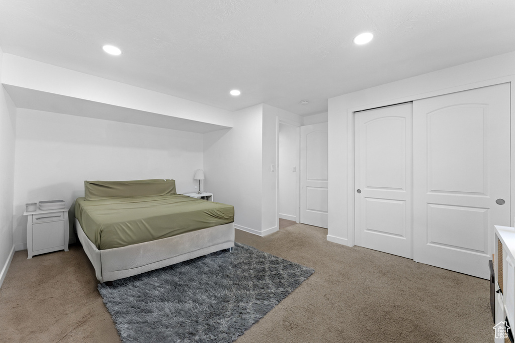 Carpeted bedroom with a closet, recessed lighting, and baseboards
