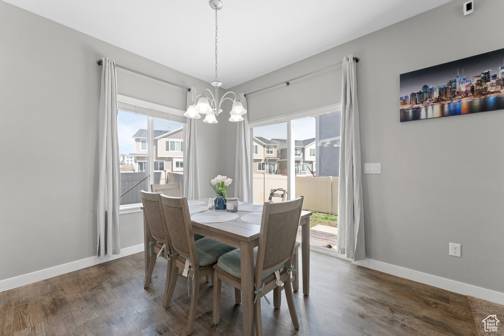 Dining room featuring a chandelier, dark wood-style flooring, and baseboards