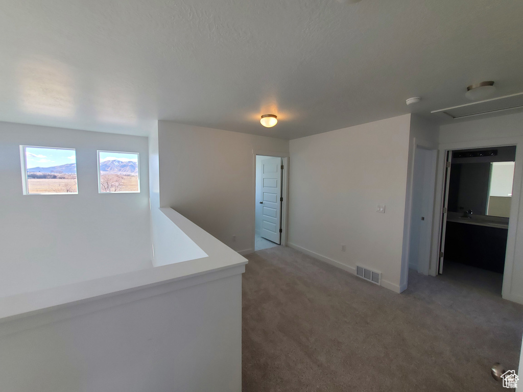 Hall featuring baseboards, visible vents, and carpet floors