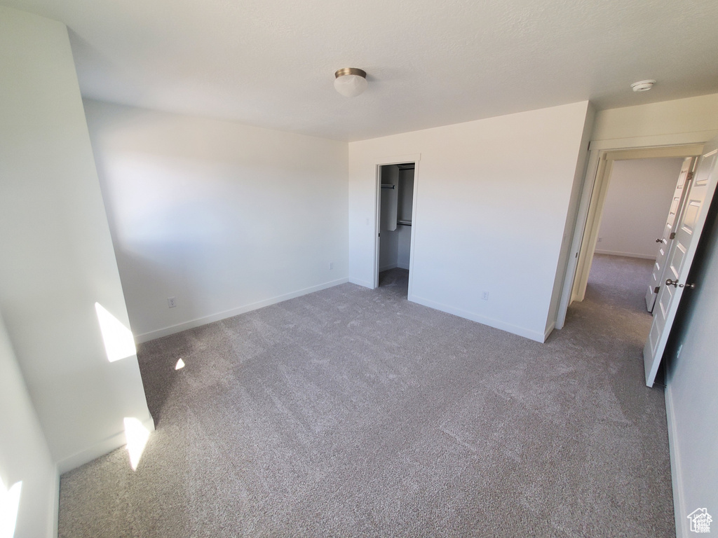 Unfurnished bedroom with carpet floors and baseboards