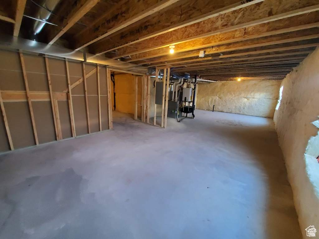 Unfinished below grade area featuring water heater