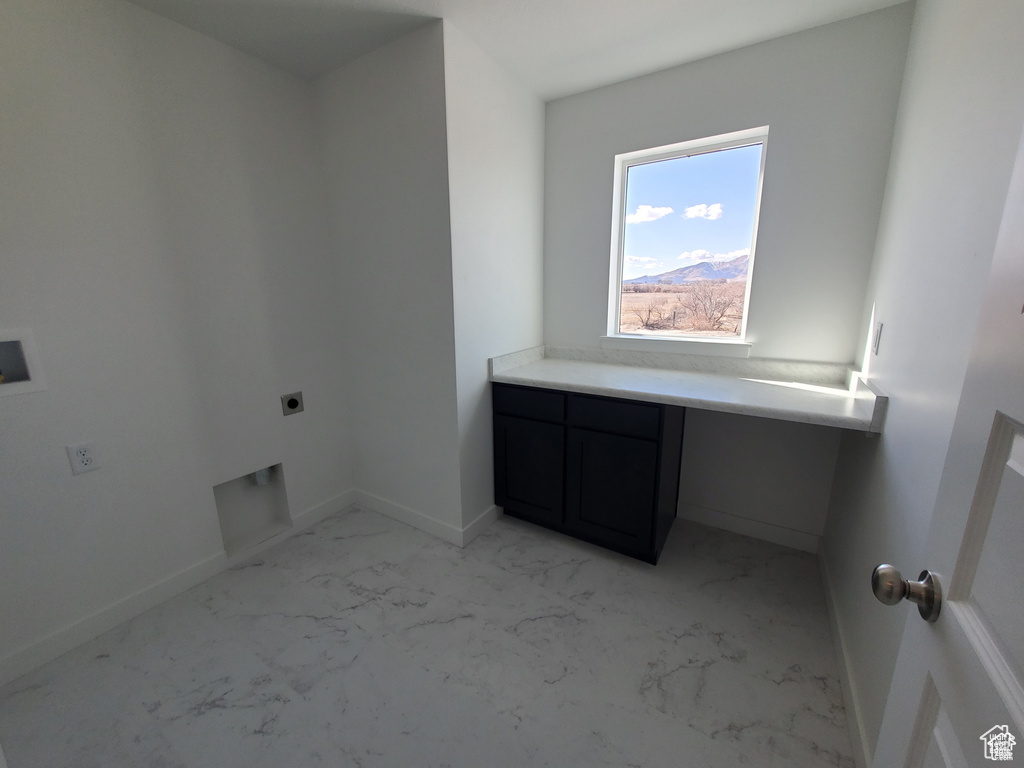 Laundry area with marble finish floor, hookup for an electric dryer, baseboards, and cabinet space